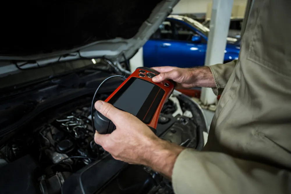 Technician running computer diagnostics on a car in Dubai