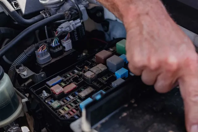 Technician diagnosing car electrical system in Dubai workshop